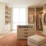 Dressing spacieux et lumineux aux tons neutres avec îlot central, étagères organisées et penderies intégrées.